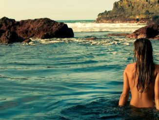 Woman being comfortable naked on a clothing-optional beach