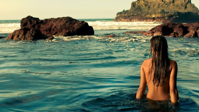 Woman being comfortable naked on a clothing-optional beach